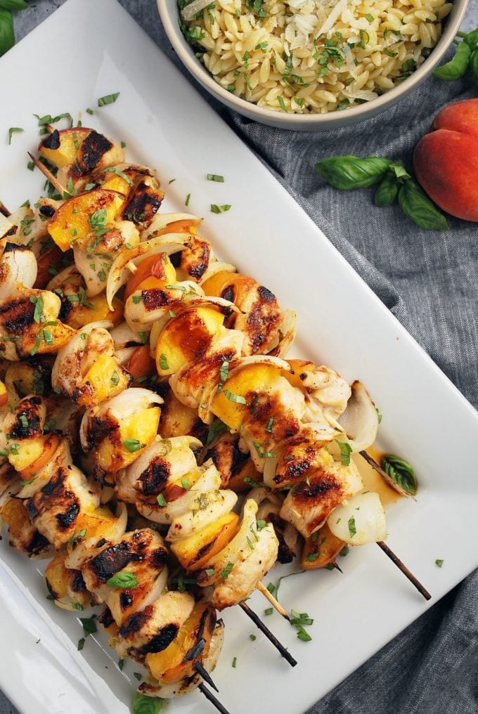 platter of peach chicken kabobs with peach and orzo pasta