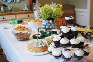 Food spread on a dining room table for a gentlemen baby shower