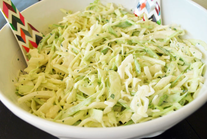 bowl of lime healthy slaw with serving spoons