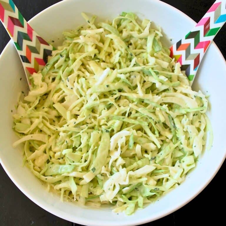 slaw in a bowl with serving spoons