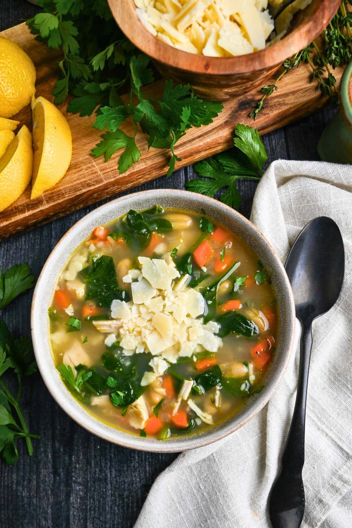 a bowl of chicken soup with shredded parm on top