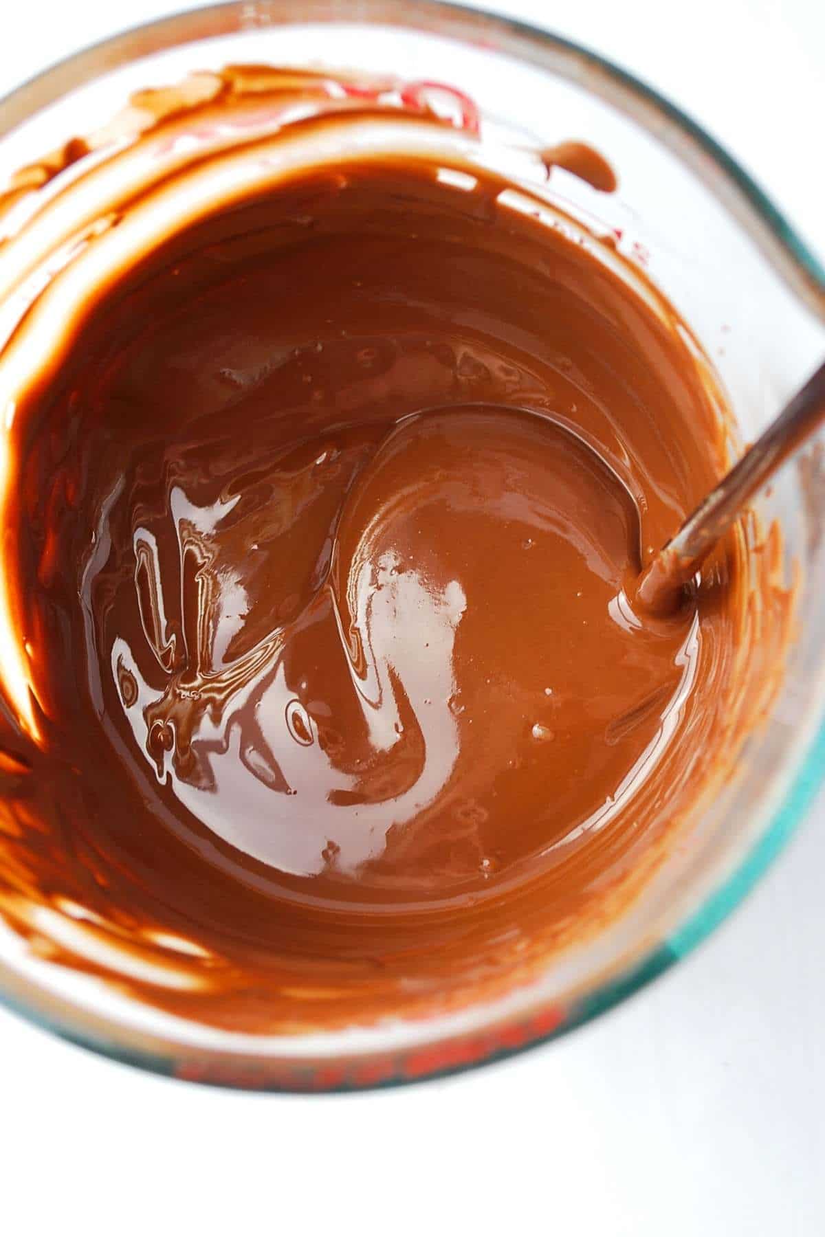 chocolate melted in a Pyrex dish with a spoon