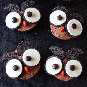 chocolate cupcakes with owl faces made with oreo cookies and M&M's candies