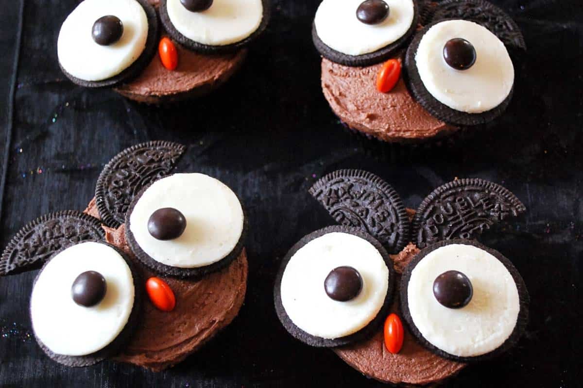 four owl cupcakes with oreo eyes and a m&m nose