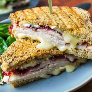 close up of a turkey cranberry brie sandwich with cheese oozing out