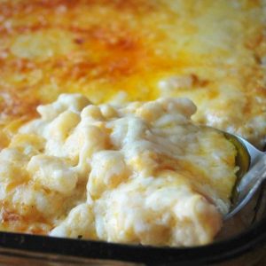 pan of gluten-free macaroni and cheese with a spoon dipping in the corner