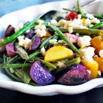 multi-colored fingerling roasted potato salad with green beans and feta cheese in a serving dish