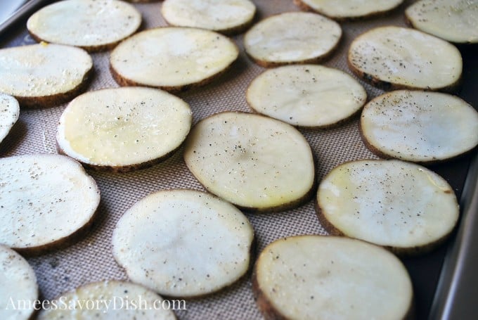 sliced uncooked potatoes ready to bake