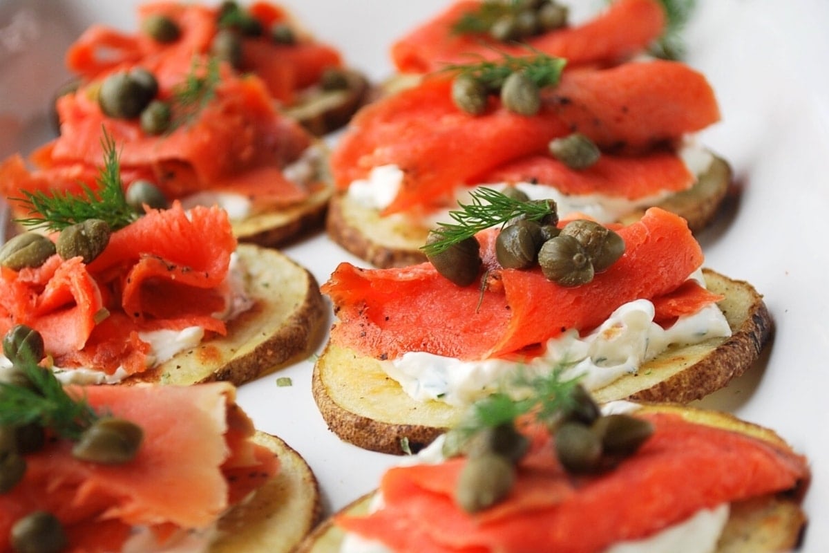 a platter of smoked salmon bites with capers and dill