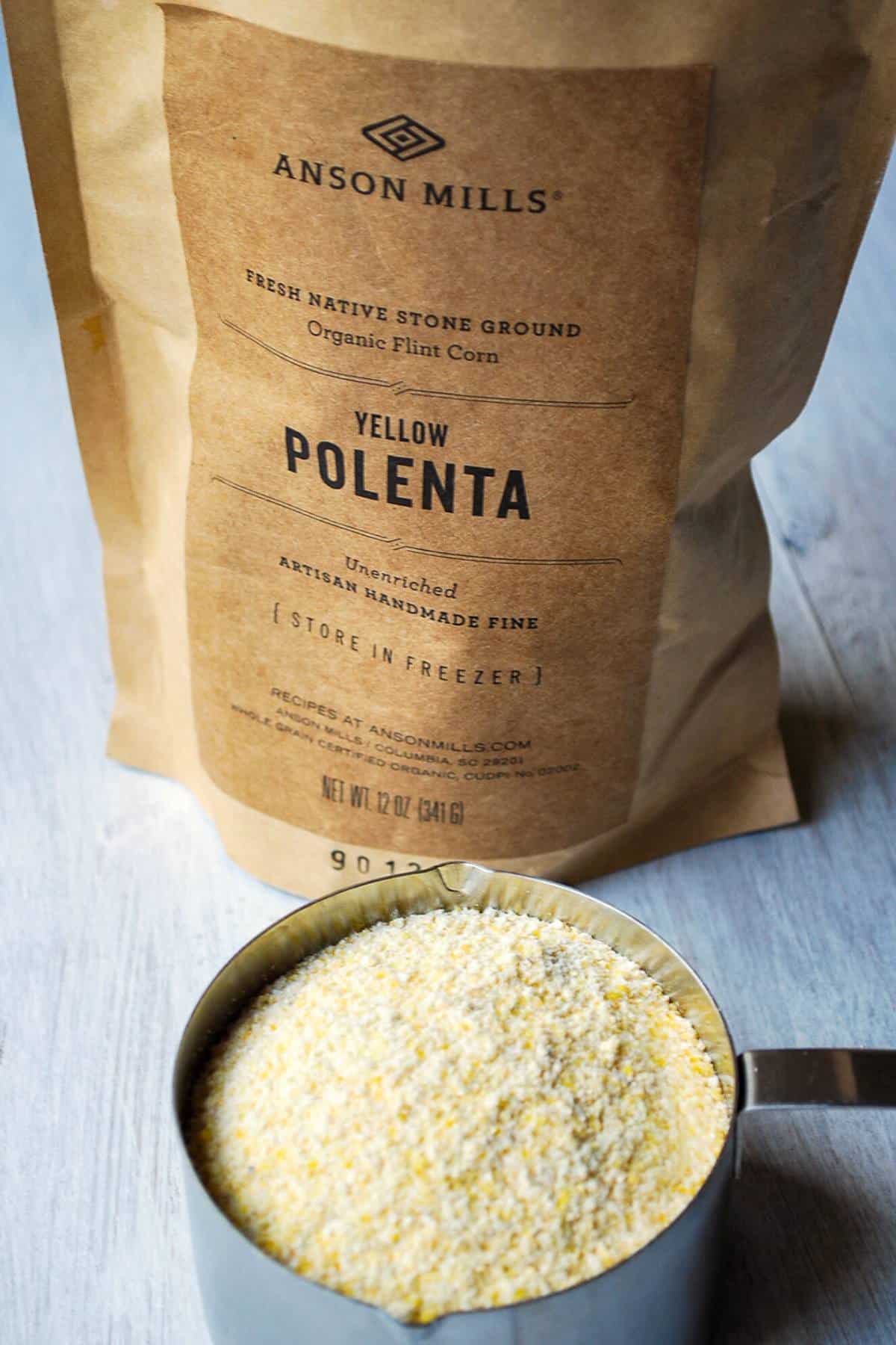 a bag of polenta with a measuring cup full of polenta in front