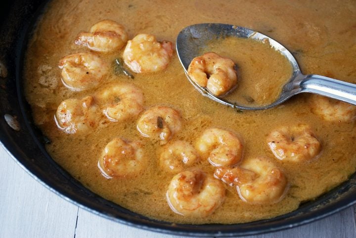 barbecue shrimp in skillet with spoon
