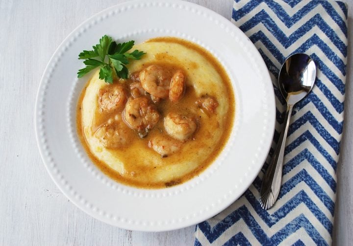 bowl of shrimp and grits with spoon and napkin