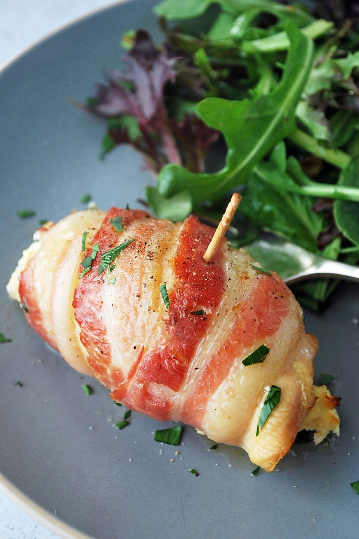 Tex-Mex bacon-wrapped chicken on a plate with salad and a fork