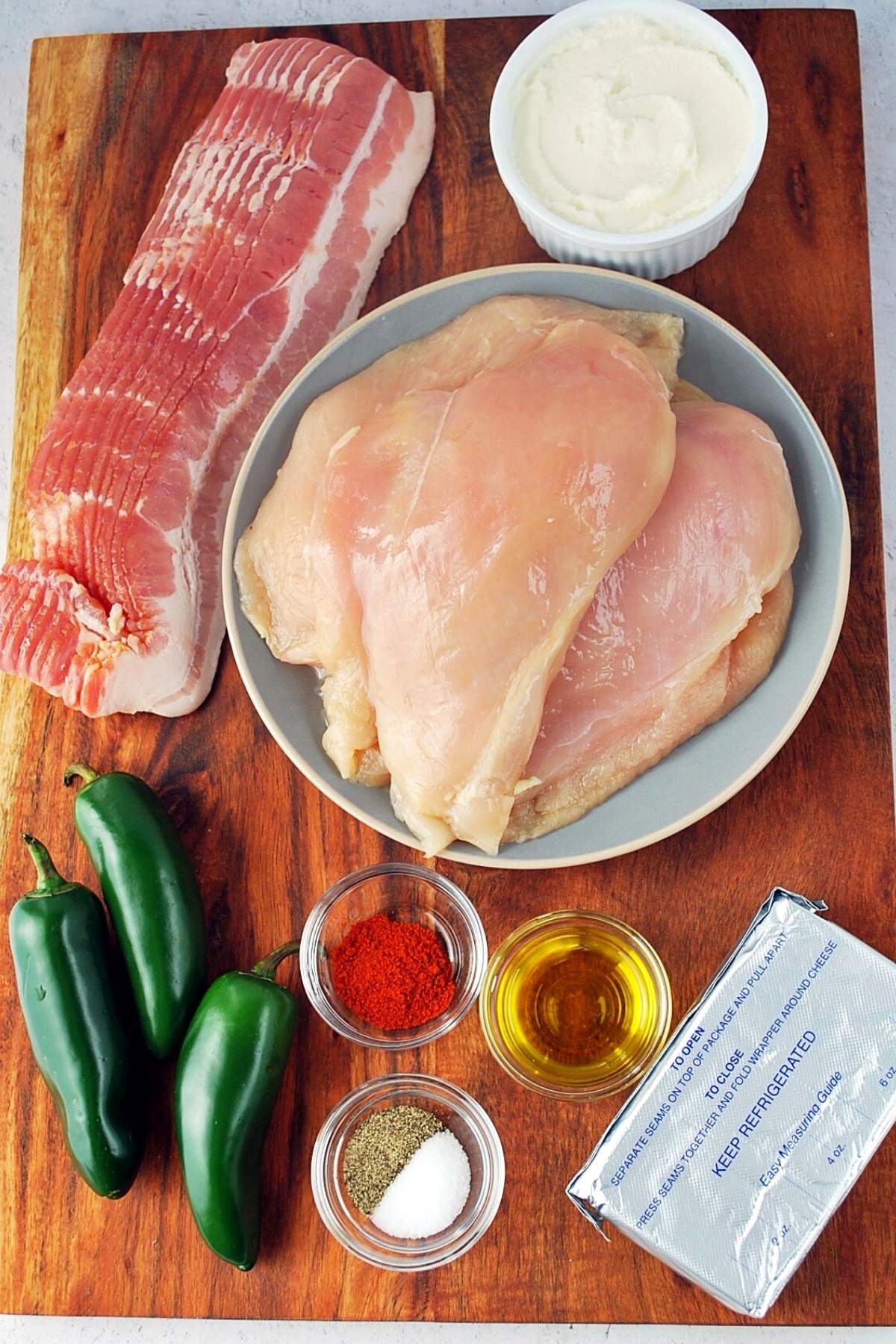 ingredients for bacon-wrapped stuffed chicken on a cutting board