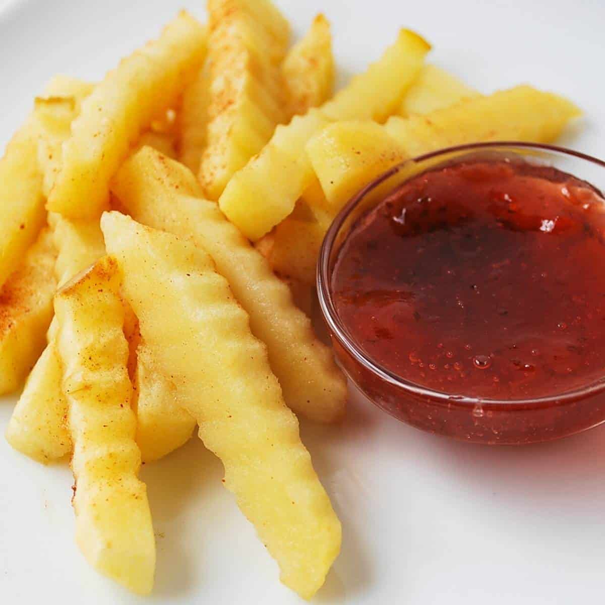 close up of apple fries with jam on a plate