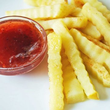 apples cut like French fries with a dish full of strawberry jam to look like ketchup