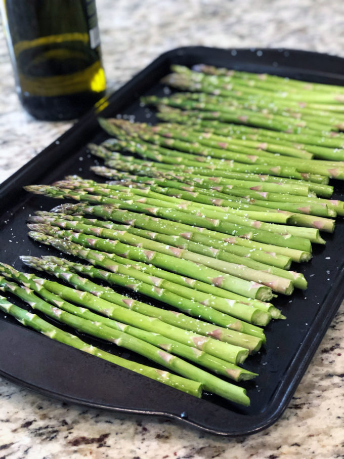 pan of fresh asparagus tossed with olive oil and coarse salt