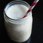 peanut butter banana smoothie in a glass with straw
