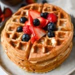 close up of a stack of protein waffles with berries on top
