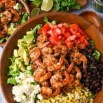 close up of grilled shrimp on top of a loaded mexican salad