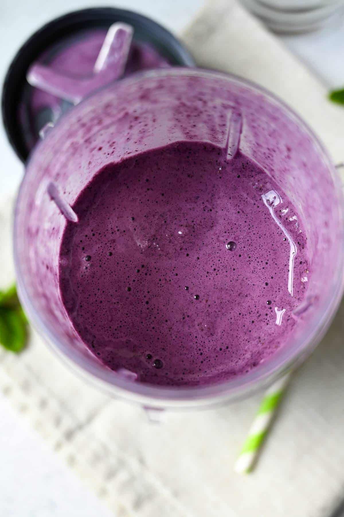 blended blueberry shake in the blender container