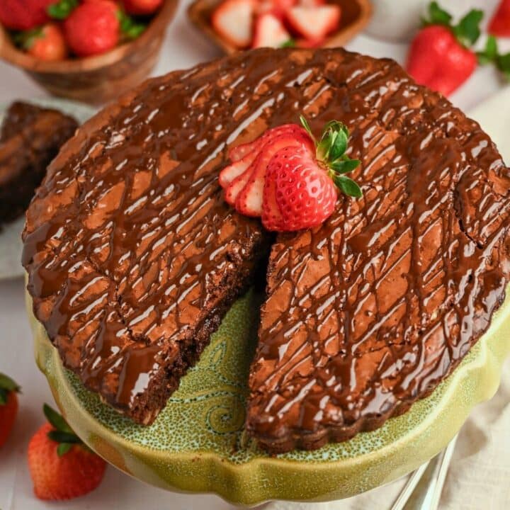 a brownie tart with a slice cut out of it with a strawberry on top