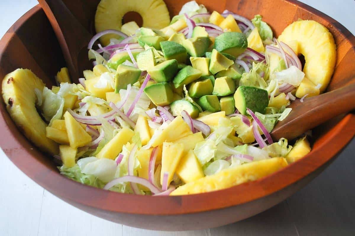 side view of a large bowl of Cuban avocado salad with a citrus lime vinaigrette dressing