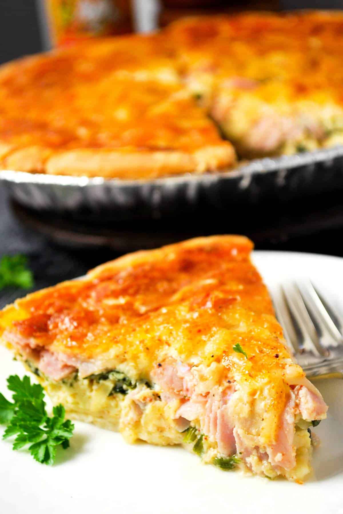 a slice of gluten free quiche on a plate with a sprig of parsley