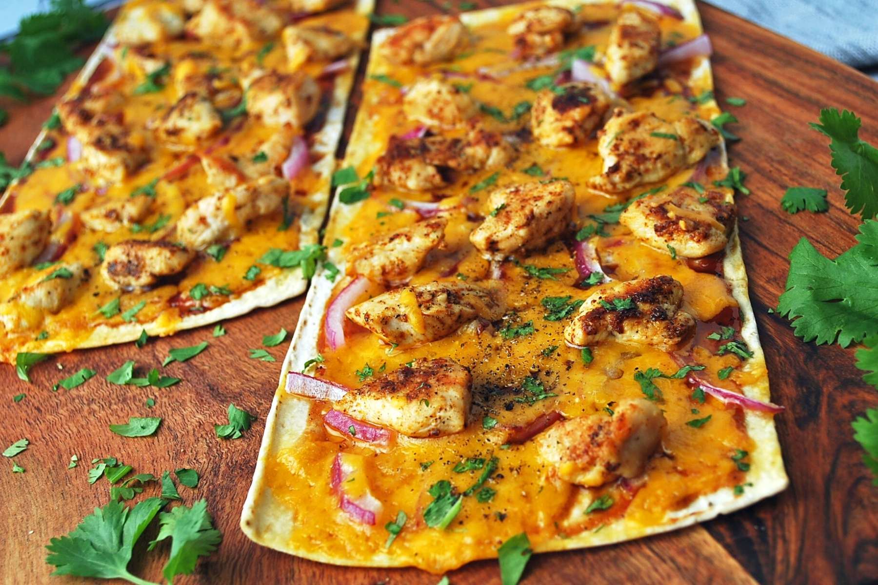 side photo of two cooked and garnished BBQ chicken flatbreads