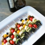Caprese skewers on a white platter