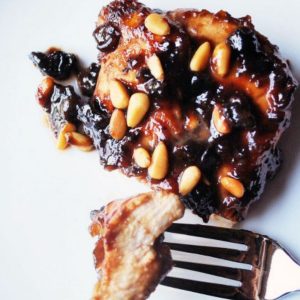 grilled chicken with plum sauce and pine nuts sliced on a plate