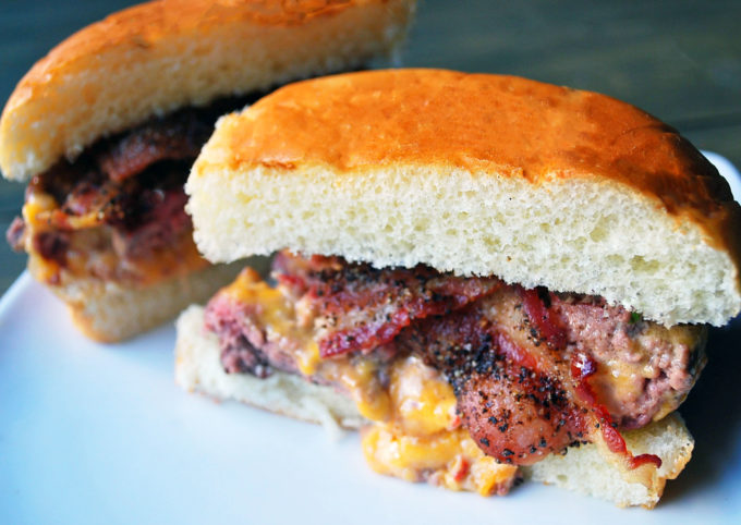 Pimento cheese stuffed burgers with peppered bacon on a plate