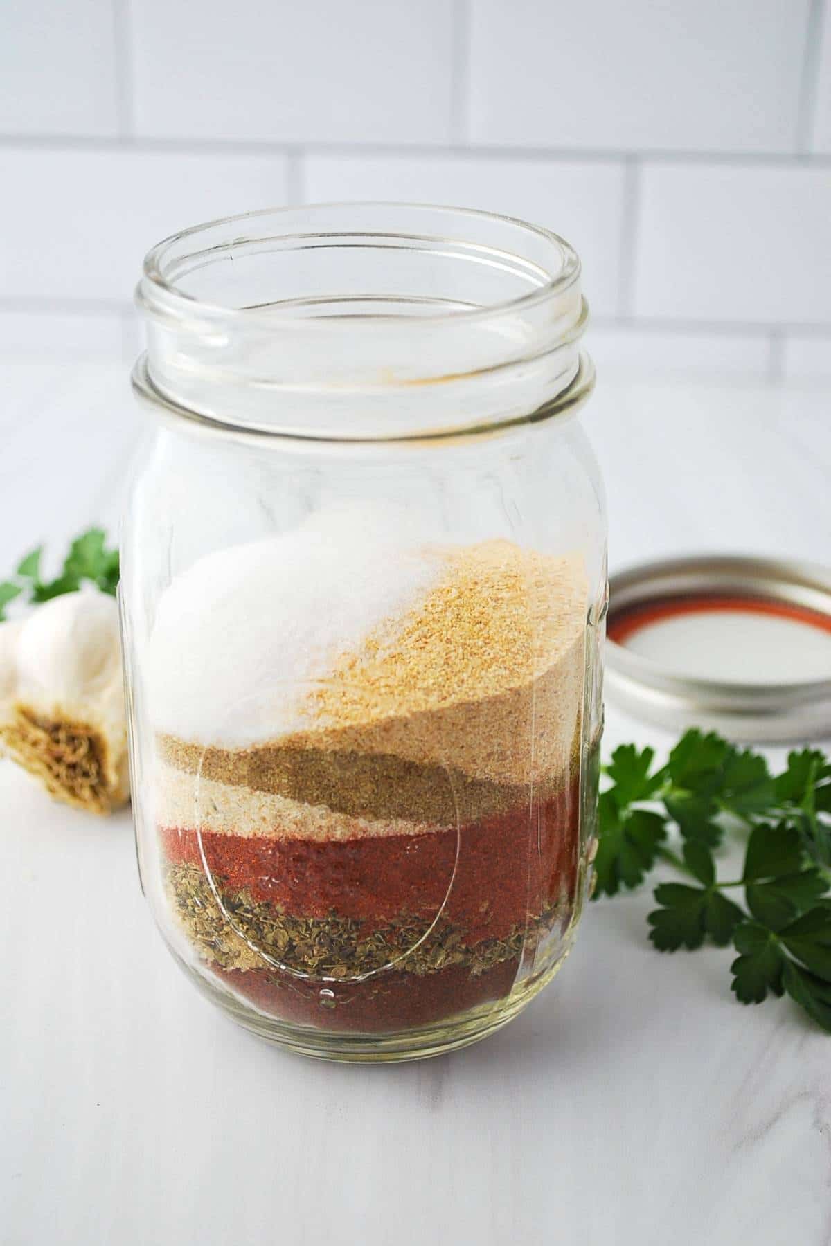 ingredients for homemade chicken taco seasoning layered in a jar