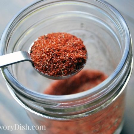 A spoonful of burger seasoning in a jar