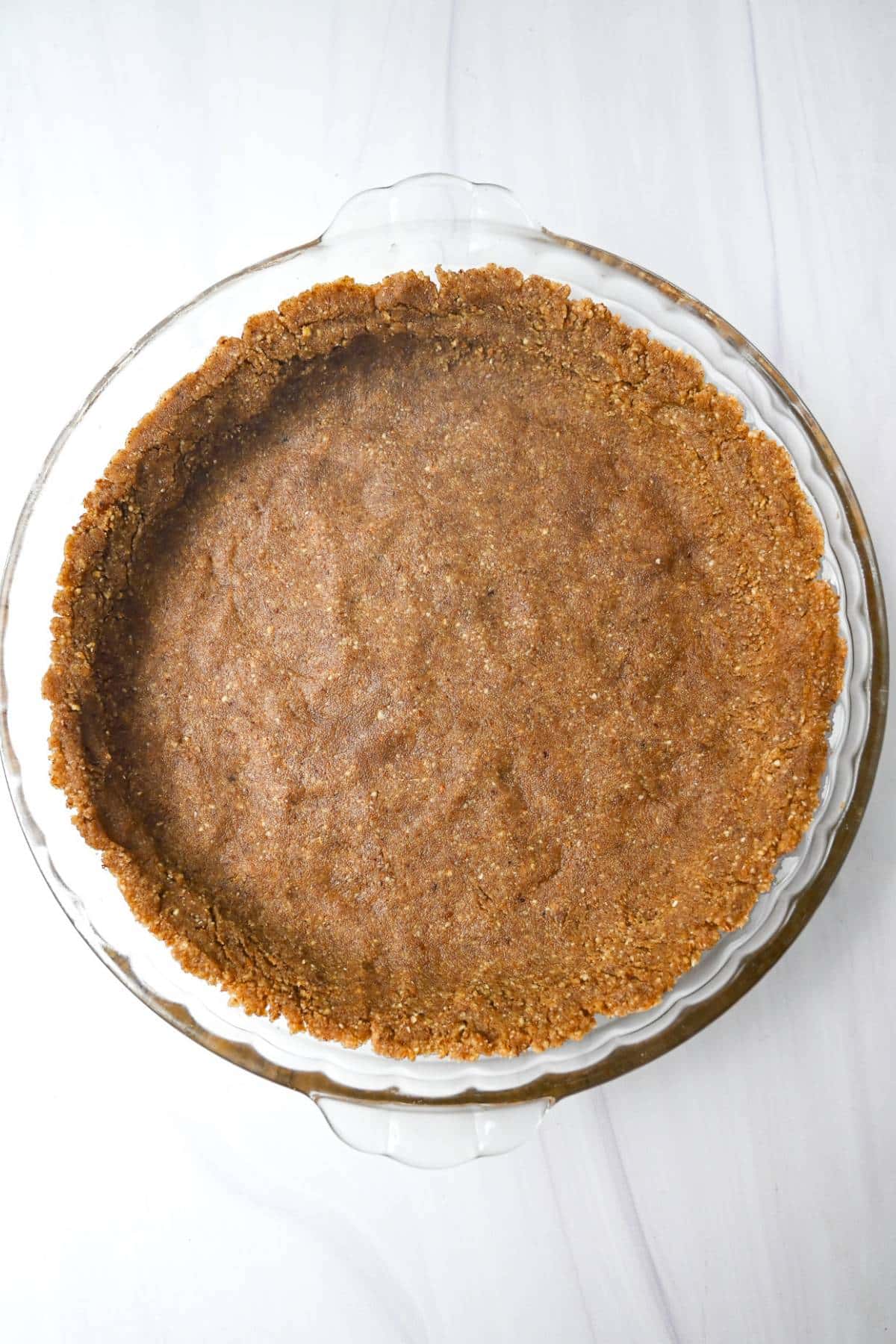 pecan pie crust pressed into a pie plate ready to bake