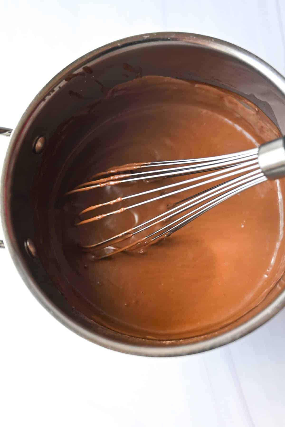 chocolate cream pie filling in a saucepan with a whisk