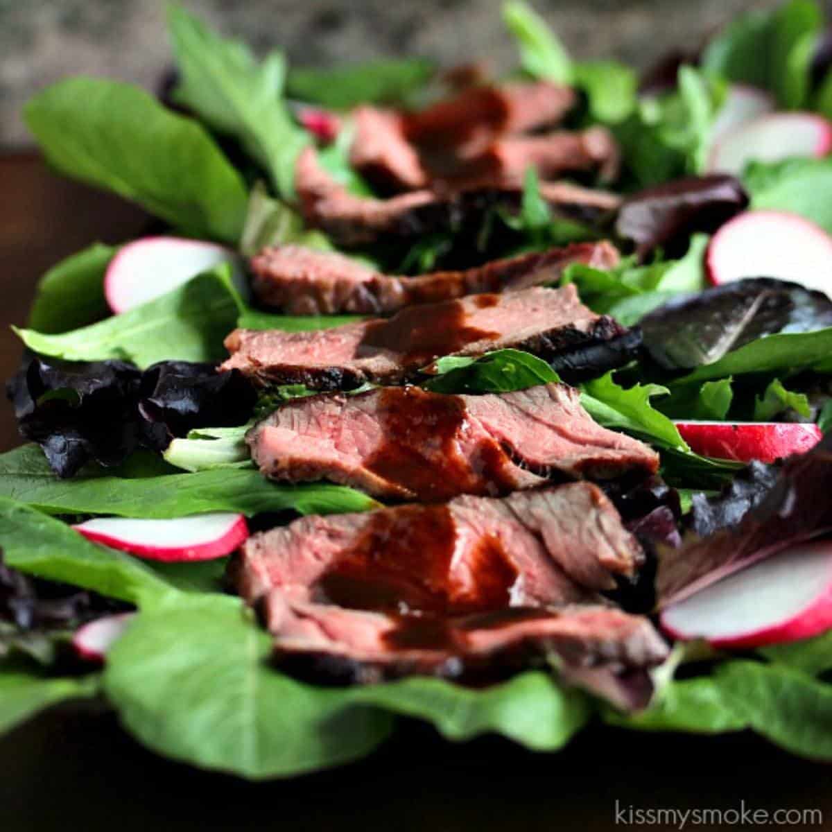 balsamic drizzled on top of a steak salad from kiss my smoke