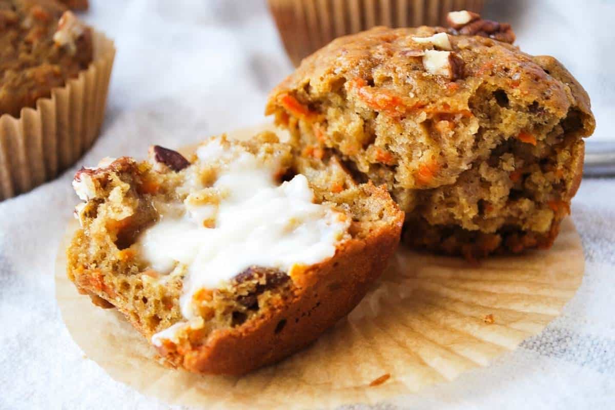 a banana carrot muffin sliced in half spread with butter