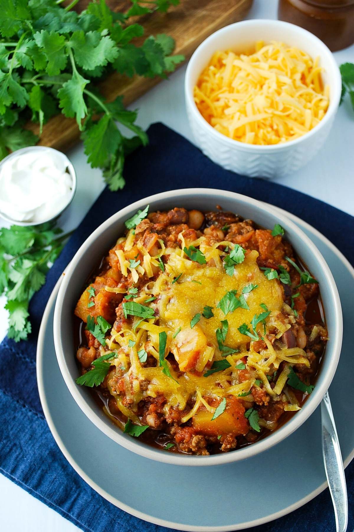 overhead photo of a bowl of chili with cheese and cilantro on top