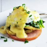 gluten free eggs benedict with spinach on a plate