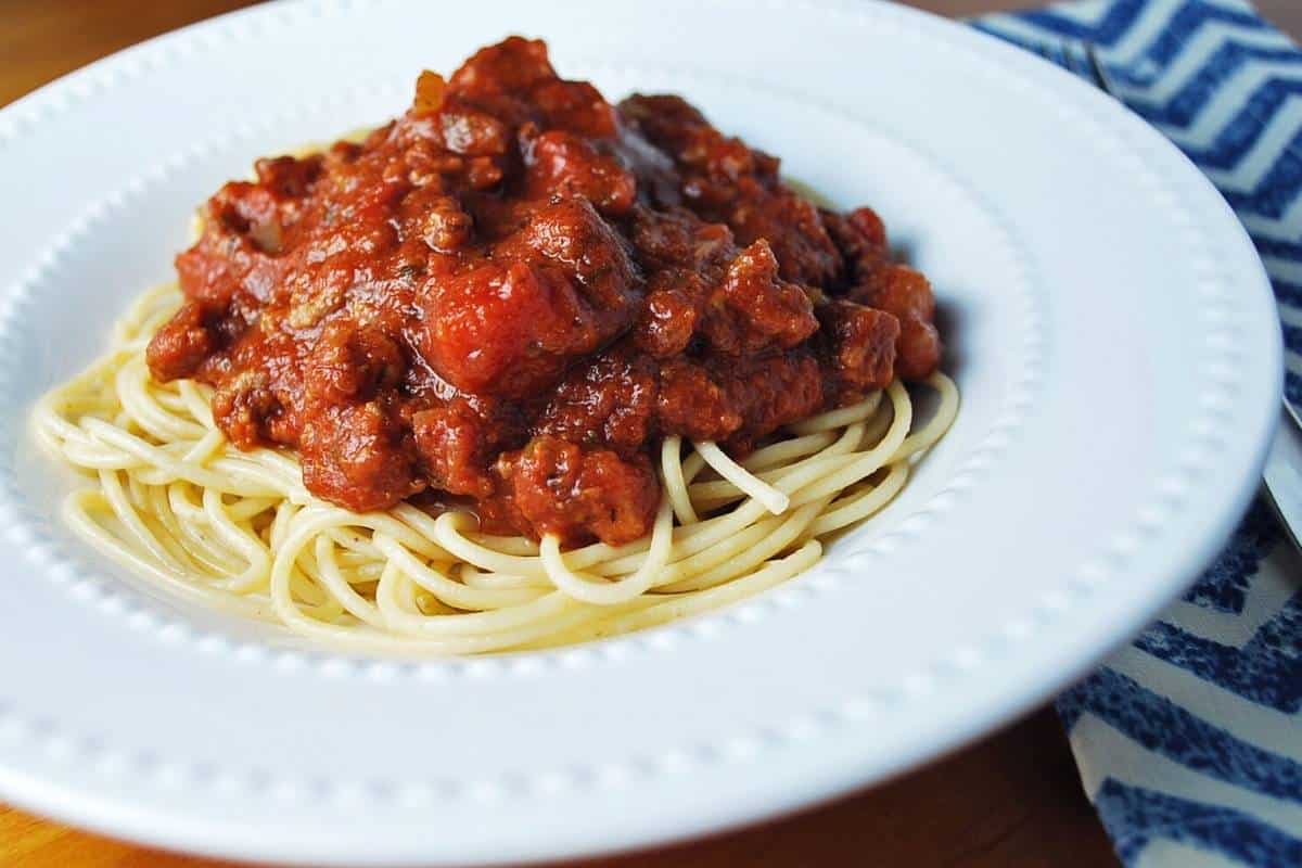spaghetti in a bowl with a chevron napkin next to it