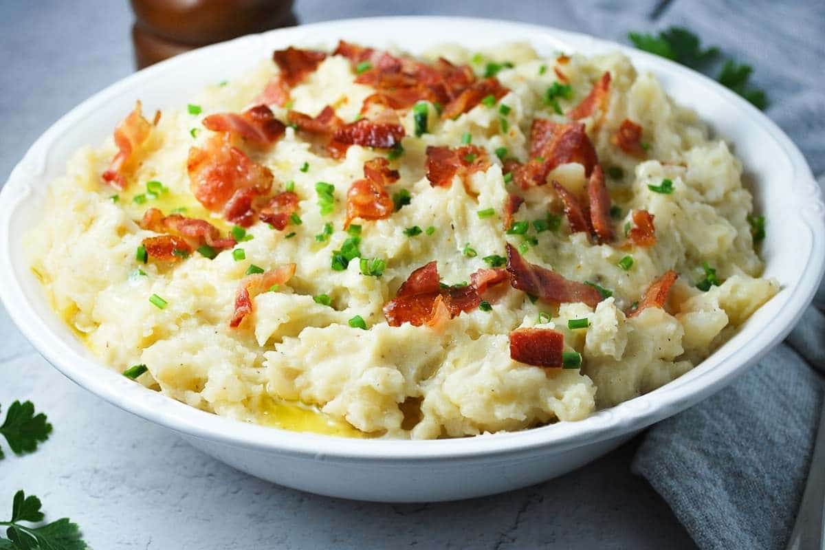 mashed potatoes in a bowl with bacon, chives, and butter