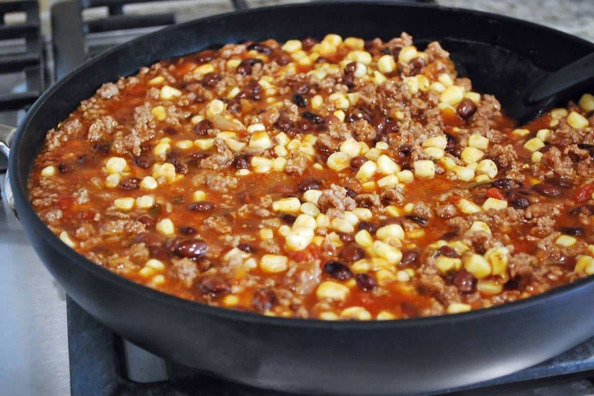 ground beef, corn, black beans and enchilada sauce cooked in a skillet