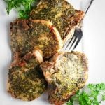 platter of herb-rubbed pork chops with a fresh herb garnish