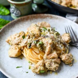 pesto chicken on top of pasta on a plate