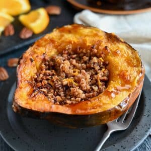 a half acorn squash air fried with a sweet nutty stuffing and drizzled in maple syrup and orange zest