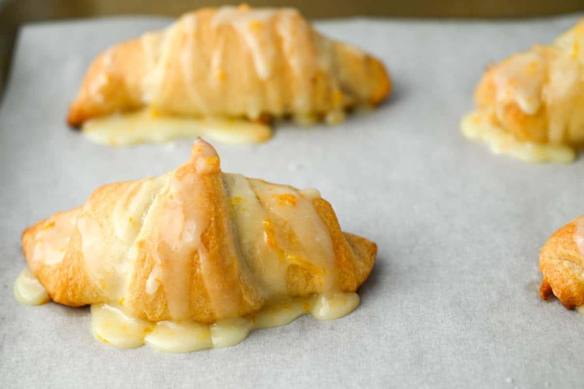 glazed croissants on a parchment lined baking sheet