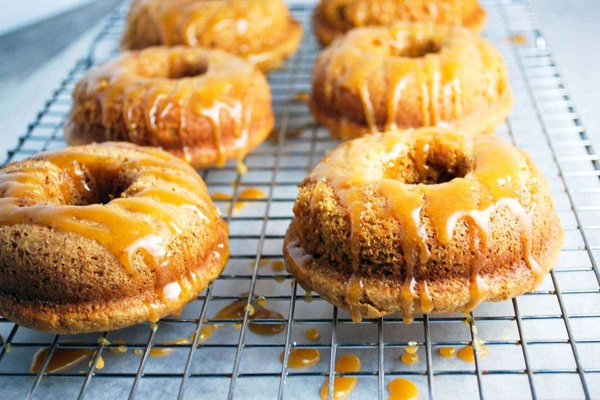 baked maple donuts dripping with glaze on a cooling rack