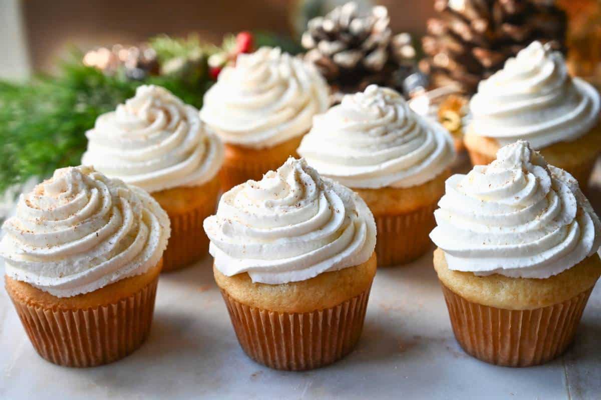 cupcakes on a cake stand with Christmas decorations behind it