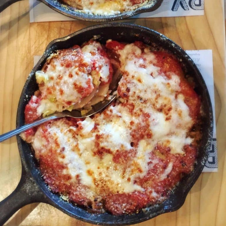 close up of a skillet of baked tomato leek gratin